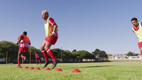 Video-Einer-Gemischten-Gruppe-Männlicher-Fußballspieler,-Die-Sich-Auf-Dem-Spielfeld-Aufwärmen-Und-Laufen