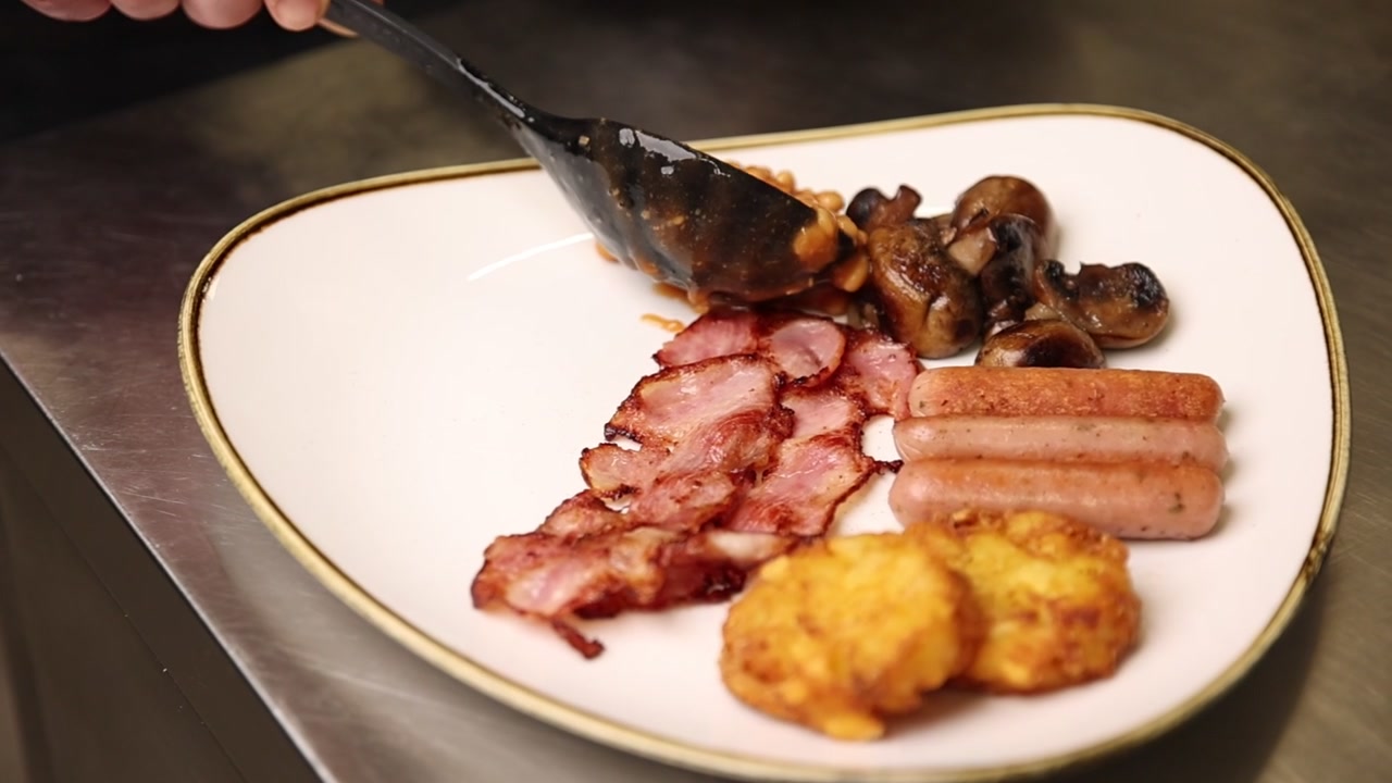 Servizio di una tradizionale colazione inglese completa con fagioli al forno