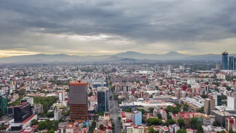 Hiperlapso-Dramático-De-Una-Ciudad-De-México-Nublada-Con-Movimiento-De-Nubes-Y-2-Volcanes-En-Primer-Plano,-Uno-De-Los-Cuales-Tiene-Nieve