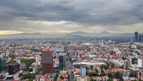 hiperlapso dramático de una ciudad de méxico nublada con movimiento de nubes y 2 volcanes en primer plano, uno de los cuales tiene nieve