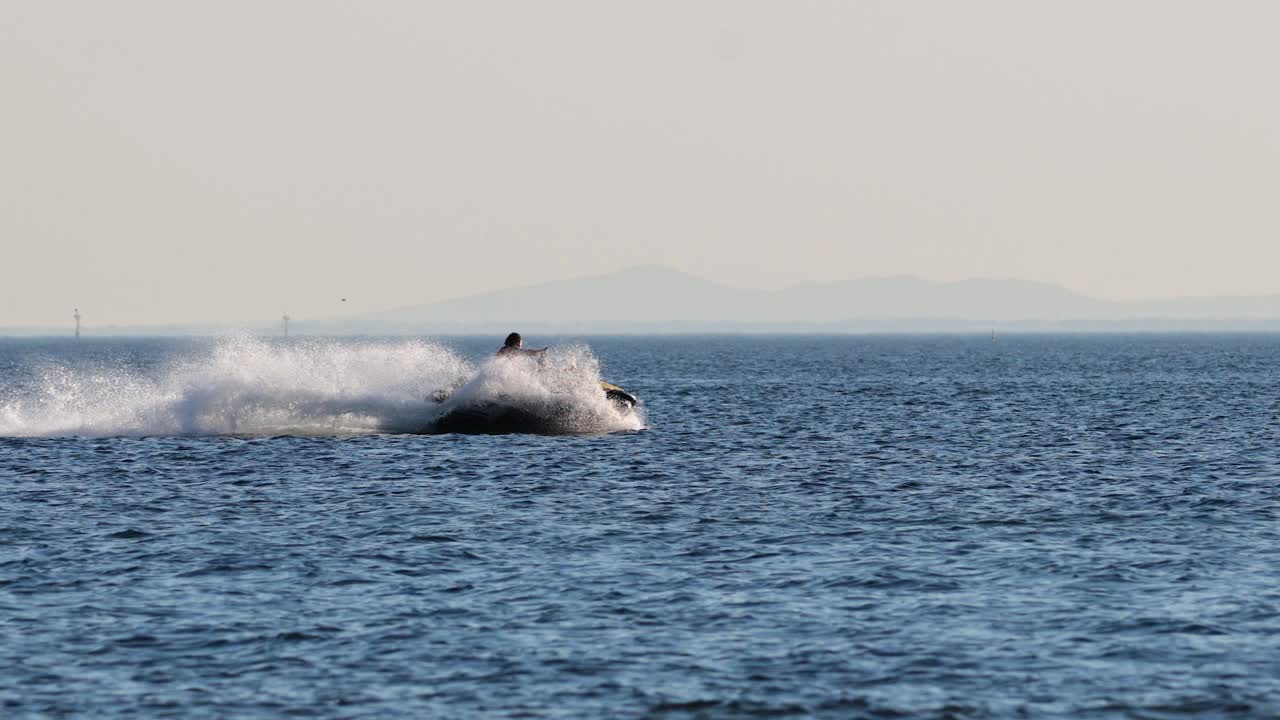 바다 에서 스턴트 를 하는 제트 스키 라이더