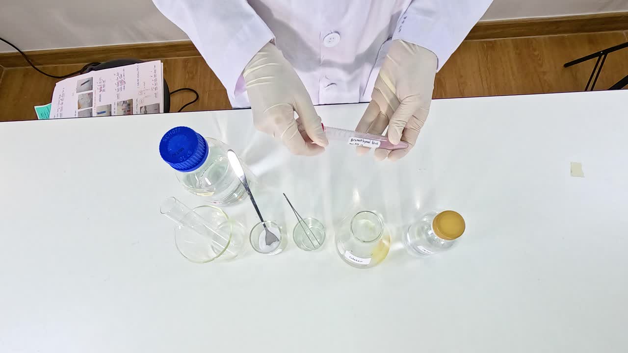 Scientist conducts a bromothymol blue experiment, observing color changes in a lab setting with controlled lighting