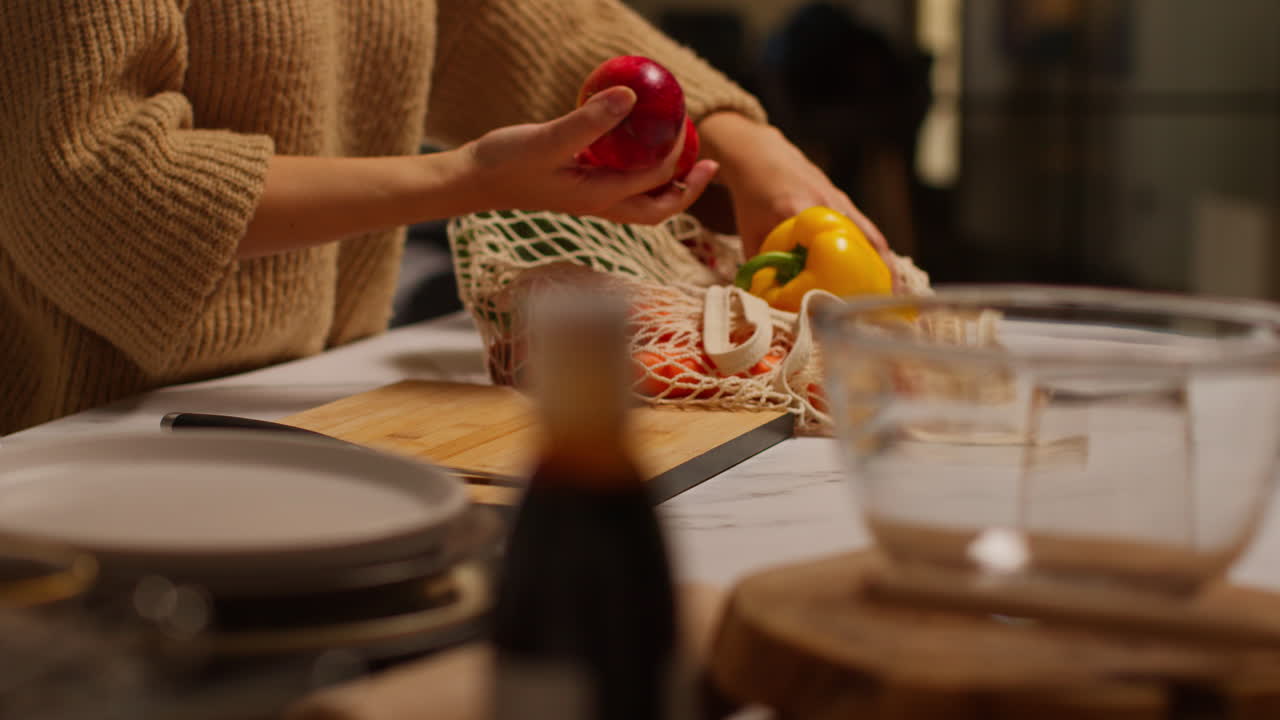 close up de una mujer desempaquetando una bolsa de verduras frescas y saludables en el mostrador de la cocina 1