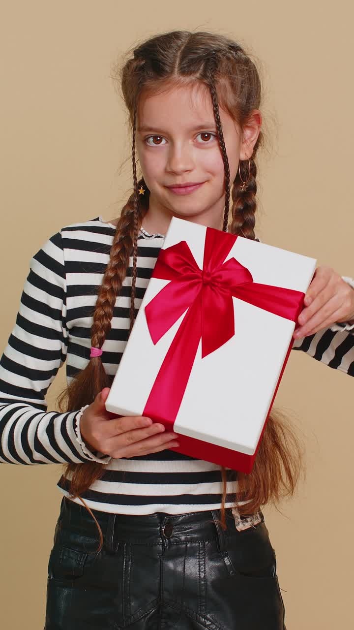 encantadora sonrisa preadolescente niña niña presentando caja de regalos de cumpleaños oferta envuelto regalo celebrando
