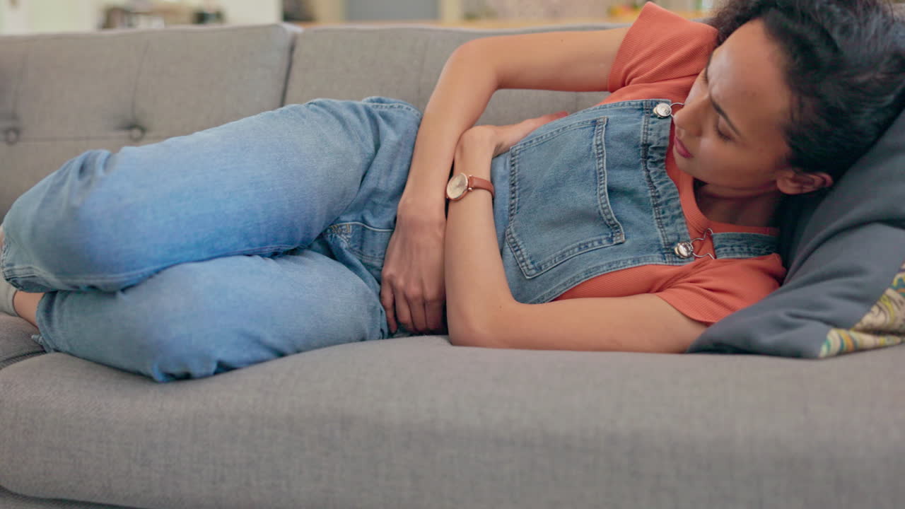 Sick woman, sofa and stomach pain for health