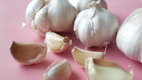 fresh garlic heads and cloves on pink background