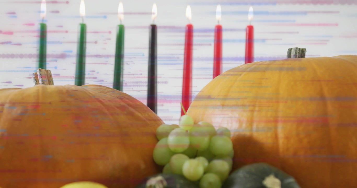 Oslava Kwanzaa se zapálenými svíčkami a plody sklizně.