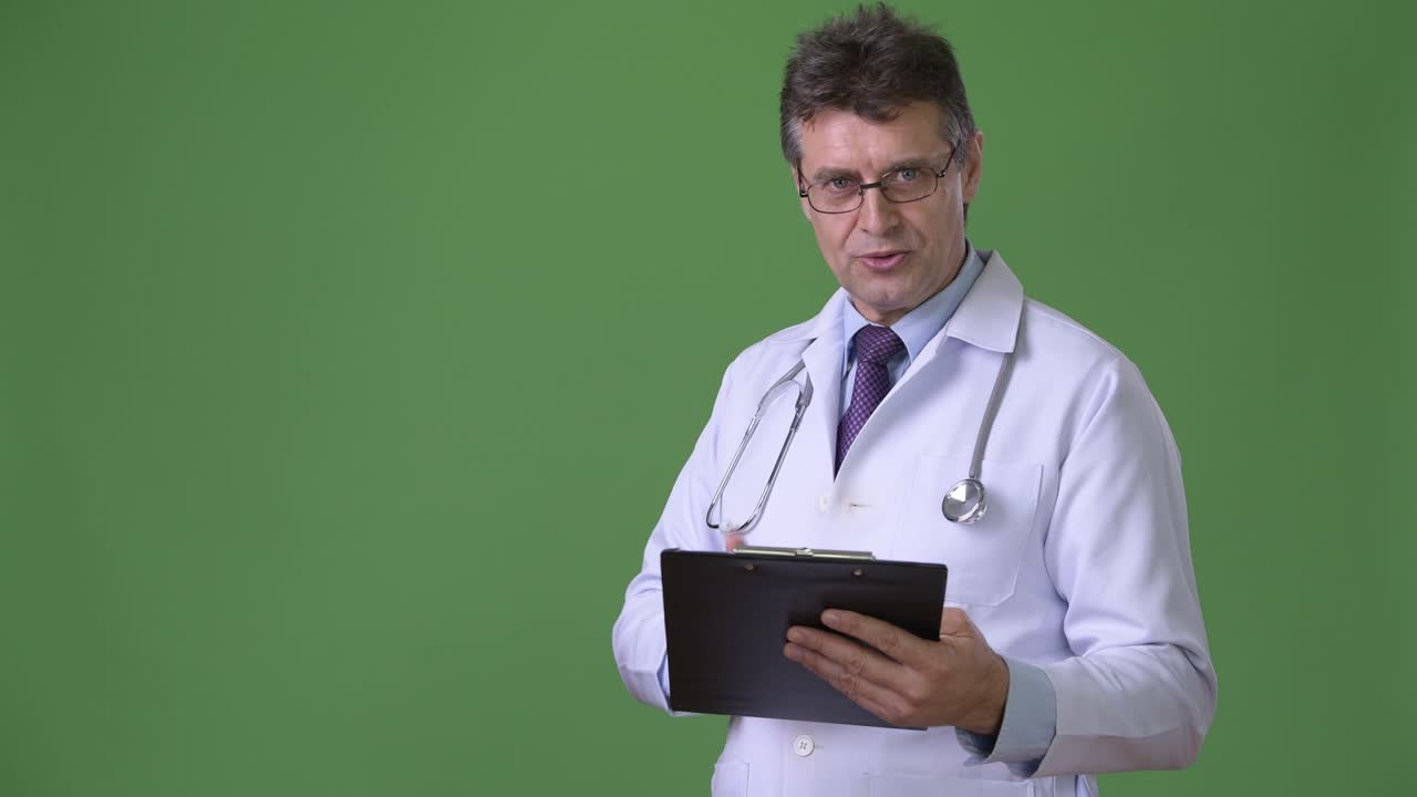 Medico uomo maturo e di bell'aspetto su sfondo verde.