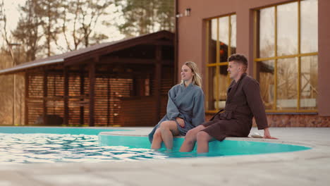 mujer joven y hombre despreocupados se están relajando en la piscina al aire libre feliz fin de semana y vacaciones