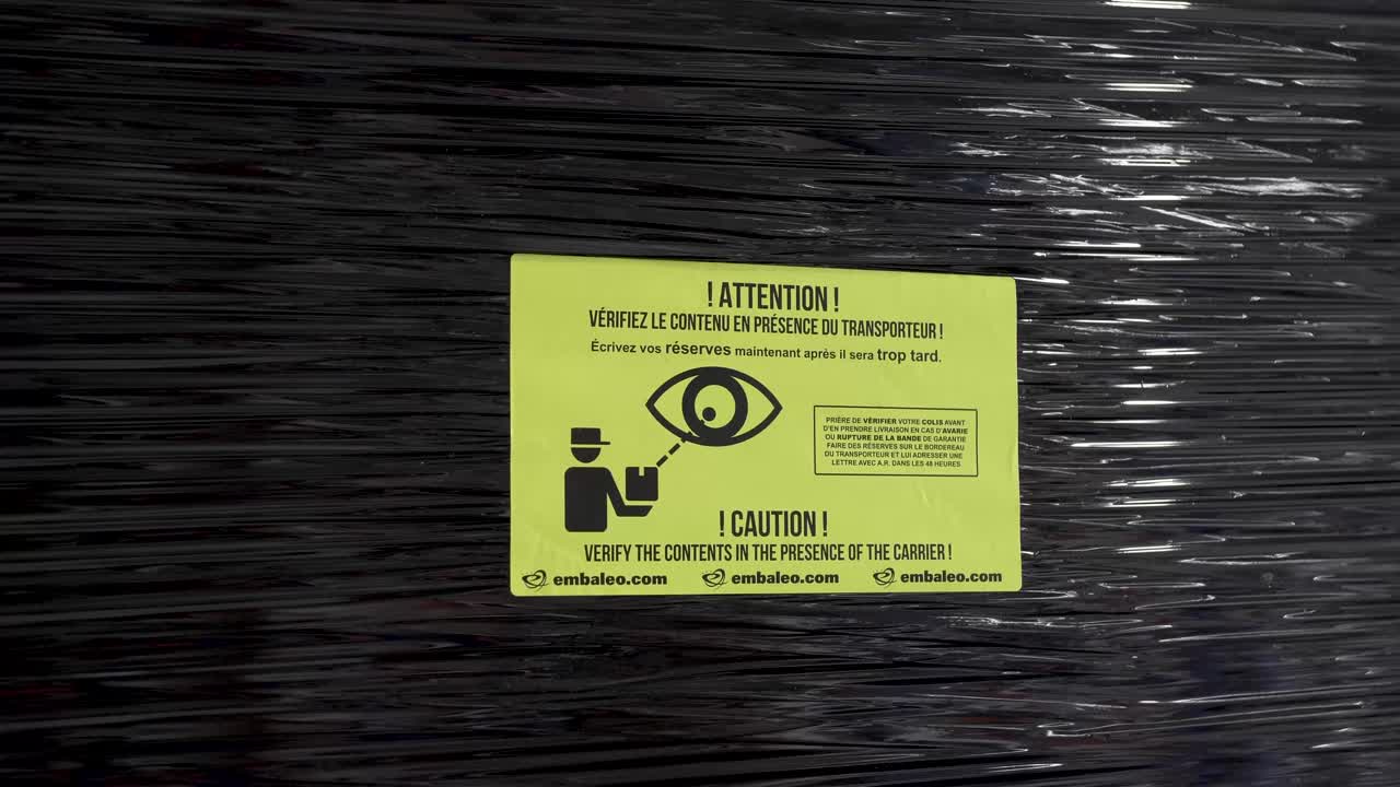 플라스틱으로 포장된 태양열 패널 선적에 확인 스티커를 붙이는 남성 손, 클로즈업 샷