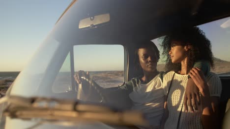 couple sitting together in pickup truck a beach 4k