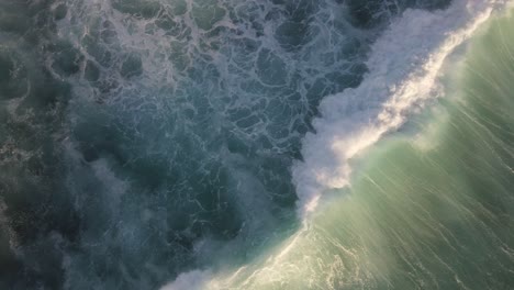 top view of beautiful wave and soft foam texture in turquoise sea water at sunset