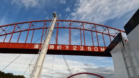 View-from-a-ferry-passing-under-the-famous-ondo-bridge-in-Kure,-Japan