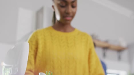 mujer afroamericana reciclando residuos en la cocina