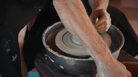 ceramist uses potter's wheel and creates a handmade clay product