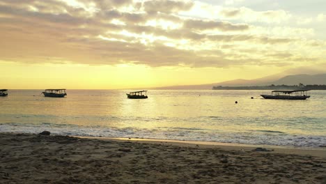 Silhouette-Von-Fischerbooten,-Die-Auf-Einer-Ruhigen-Lagune-Schwimmen-Und-Den-Goldenen-Himmel-Mit-Grauen-Wolken-Bei-Sonnenuntergang-In-Indonesien-Reflektieren