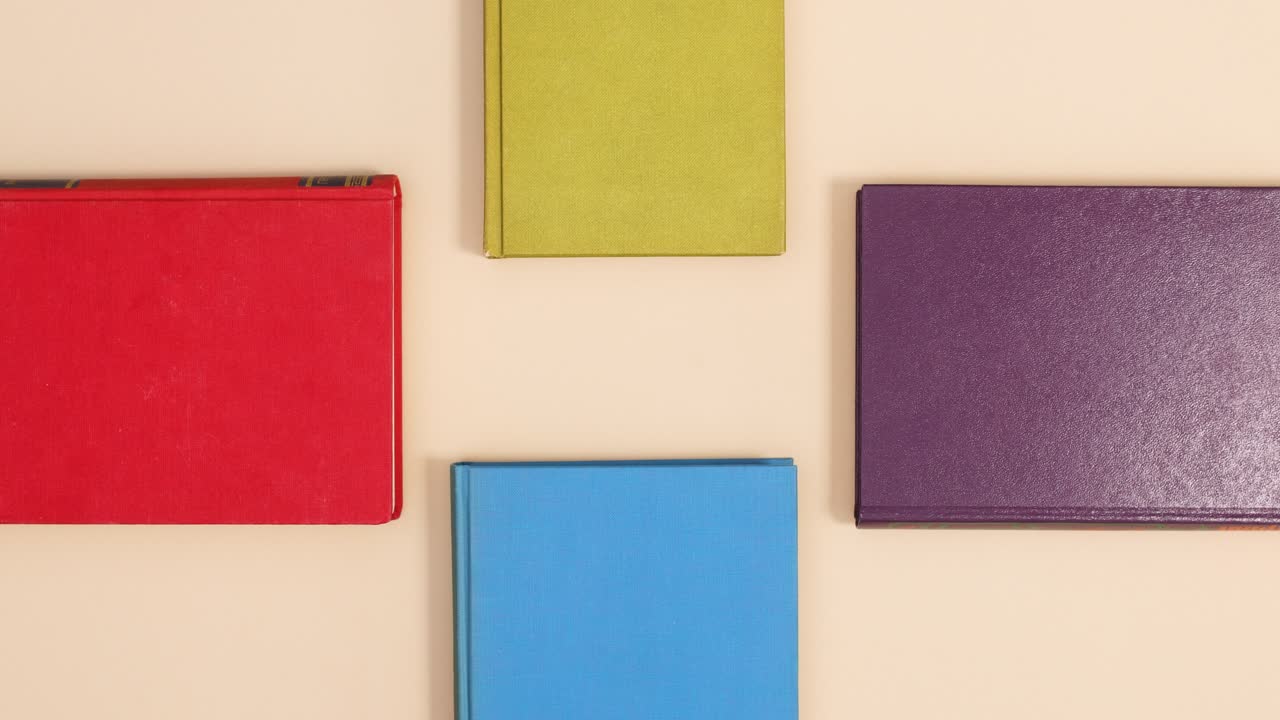 네 개의 하드 커버 빈티지 책, 네 개의 측면, 베이지색 배경, 스 모션, 플래트 레이.