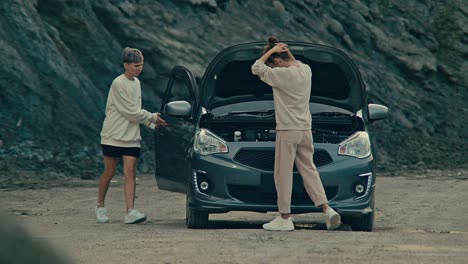 women fixing a broken down car
