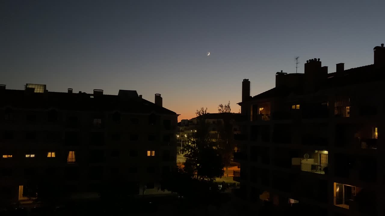 bellissimo tramonto della luna sulla città notturna con luci nelle finestre delle case