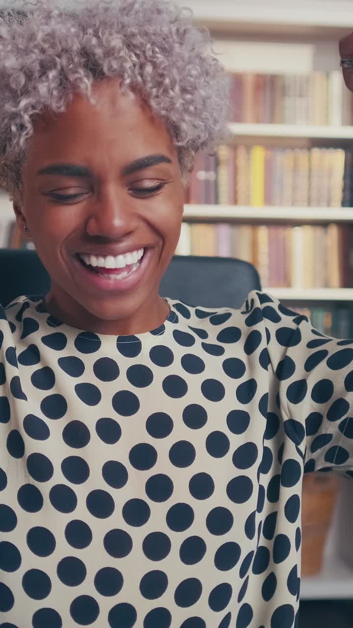 Giovane donna d'affari afroamericana balla celebrando negoziazioni riuscite.