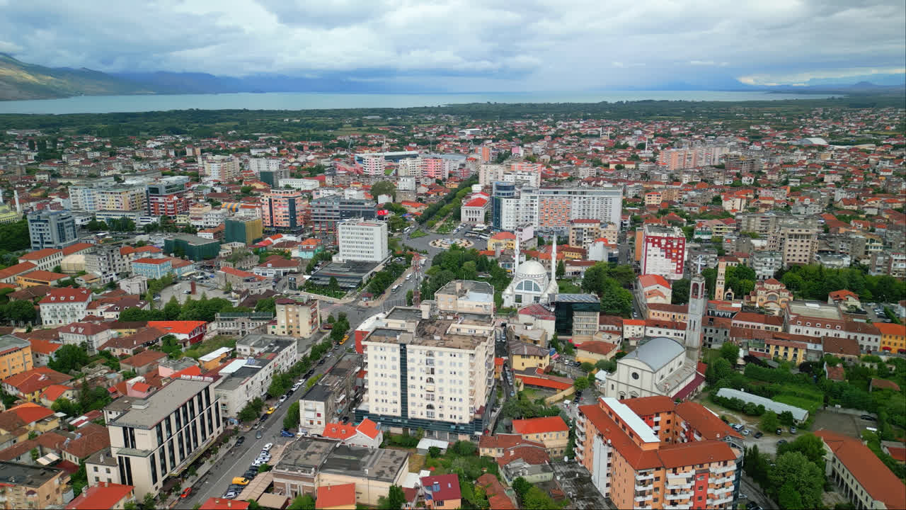 알바니아 북서부의 shkodra, 또한 shkoder 또는 scutari로 알려진 주요 도로의 양쪽에 있는 도시 건물 위에서 오른쪽에서 왼쪽으로 촬영 된 항공 드론 판