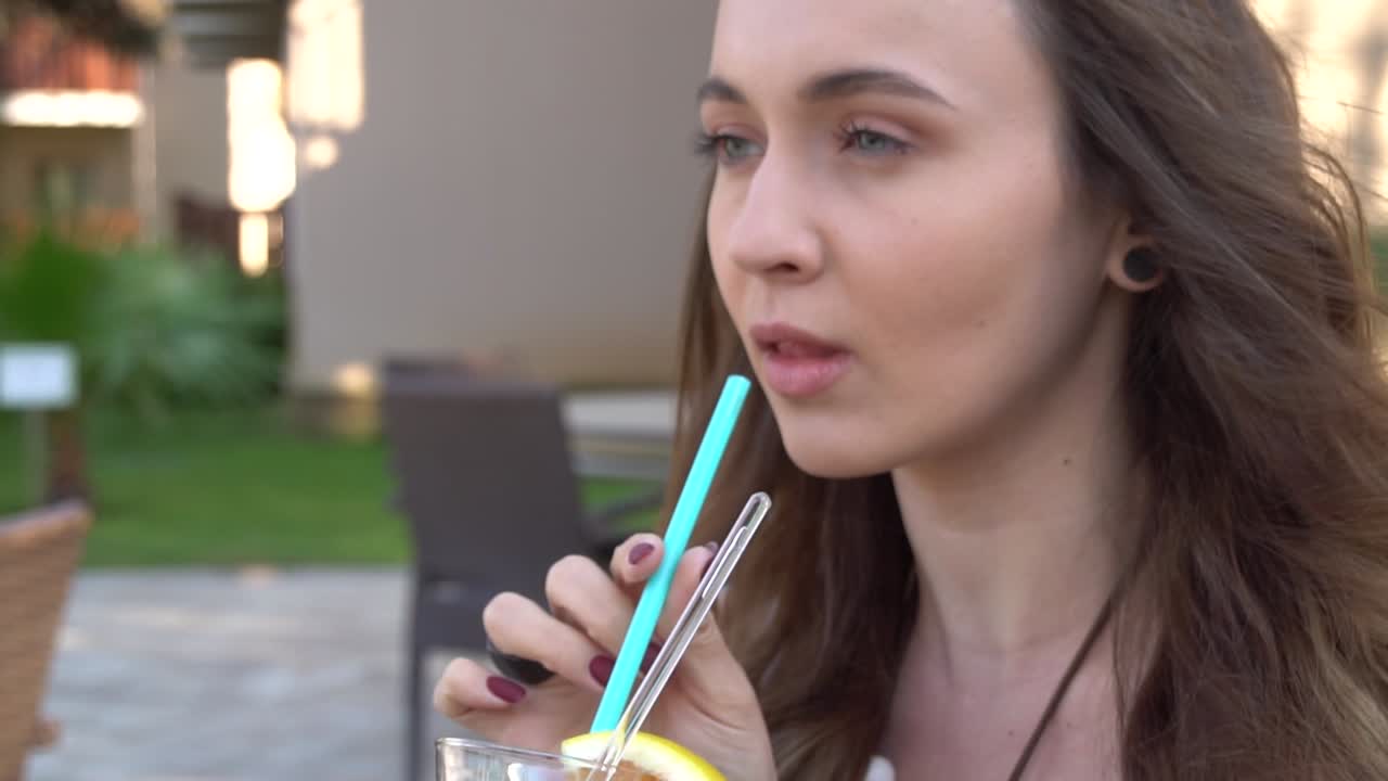 Linda garota bebe um coquetel arco-íris