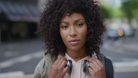 retrato de una atractiva mujer afroamericana que busca la calma pensativa en la cámara joven estudiante negra en la ciudad urbana fondo de la serie de personas reales