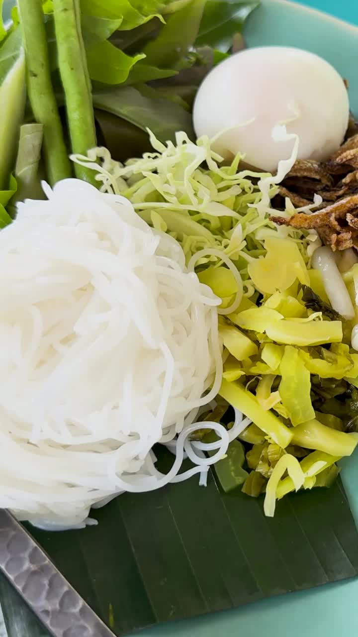 A vibrant display of Kanom Jeen Nam Ya Pu, showcasing fresh ingredients and rich curry sauce in a bright, inviting setting