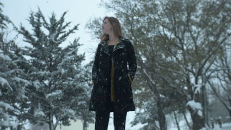 Mujer-Feliz-Afuera-En-Cámara-Lenta,-Nieve-Invernal-Navideña-Mientras-Los-Copos-De-Nieve-Caen-En-Cámara-Lenta-Cinematográfica