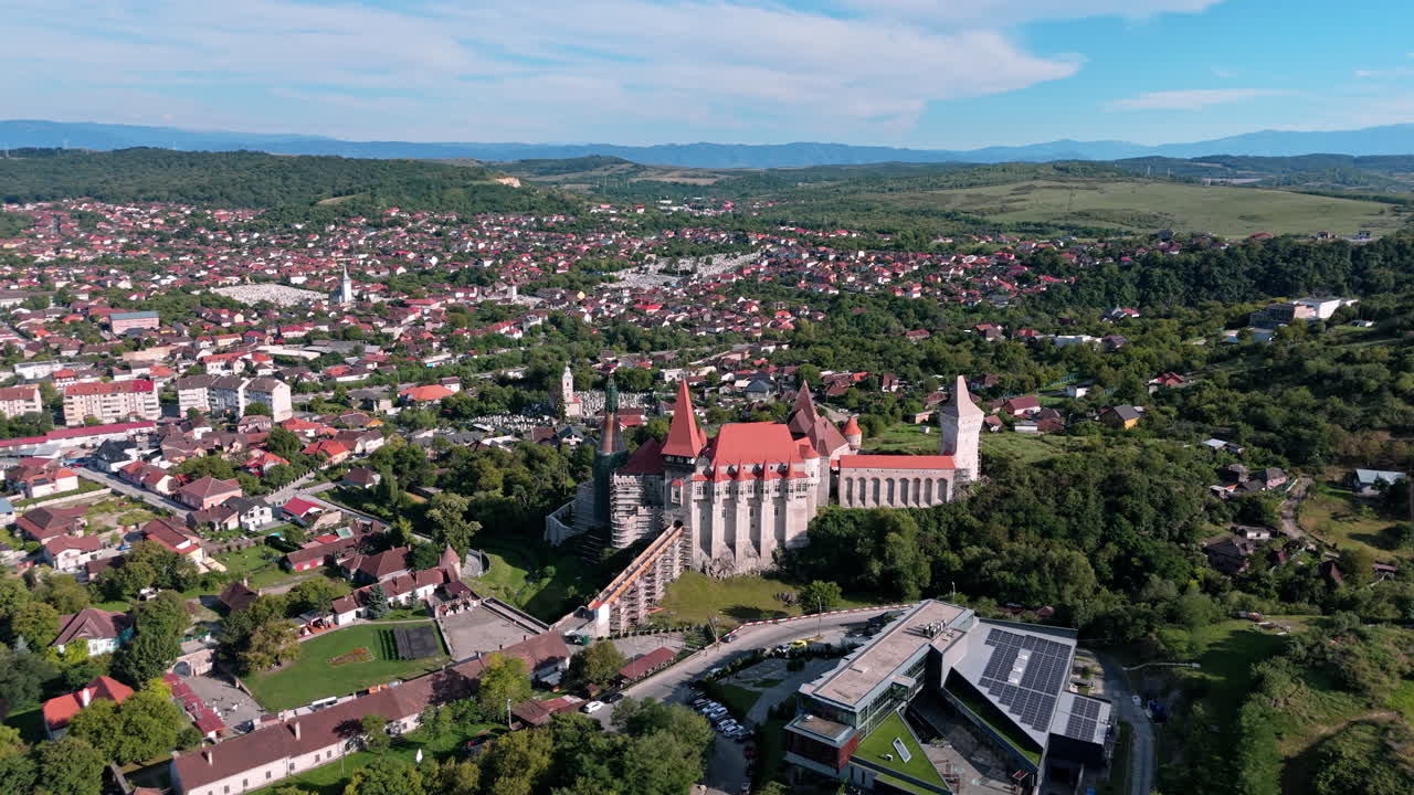 Aerial view of Corvin Castle in Hunedoara, lush landscape and townscape