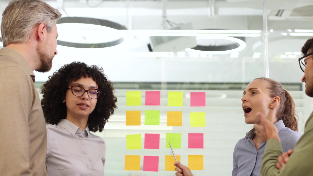Profissionais de Negócios em Brainstorming de Ideias em um Quadro de Vidro