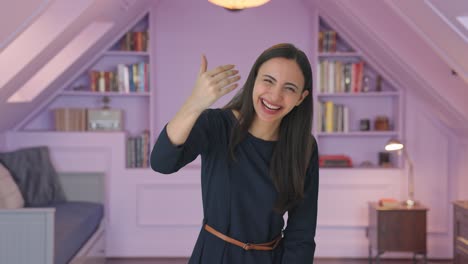 happy indian girl pointing and calling someone