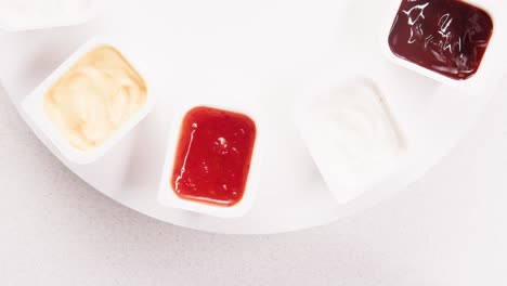 various dipping sauces in small plastic containers