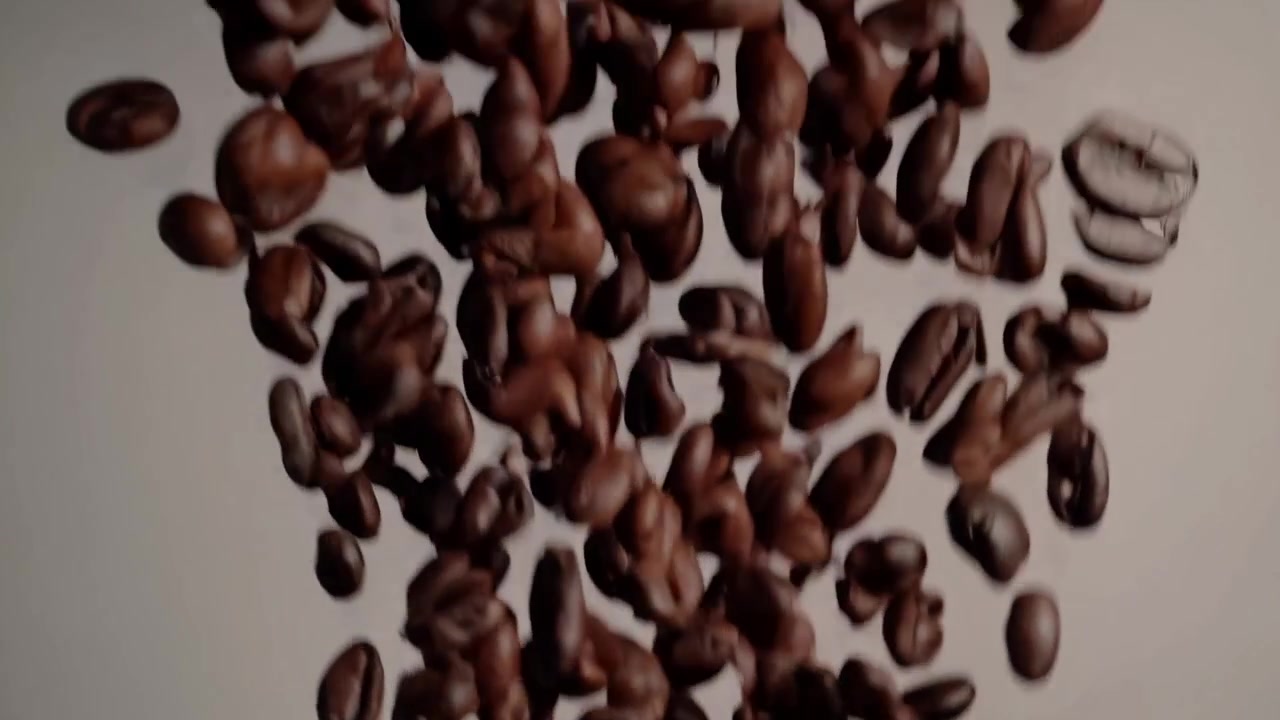 Movimento rallentato di chicchi di caffè tostati che cadono.