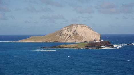 una piccola isola al largo della costa di oahu, sulla costa orientale, con l'oceano pacifico sullo sfondo e della vegetazione visibile