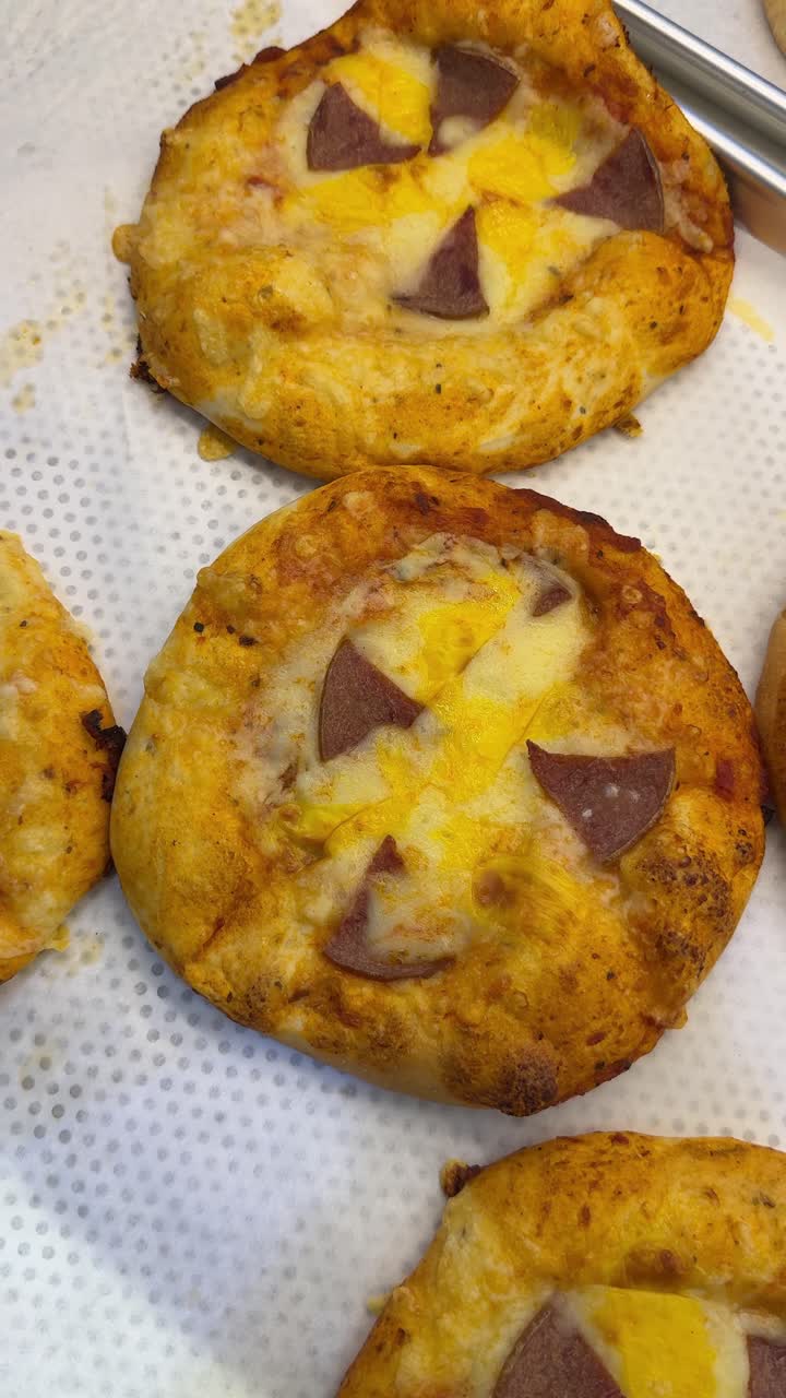 Mini pizze dorate con formaggio fuso e salame piccante