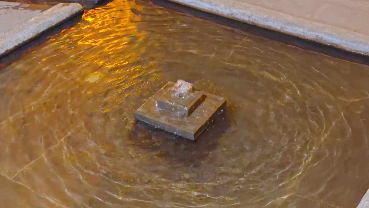 4K footage of a historic stone fountain and square pool. Features soothing water ripples in a traditional architectural setting, showcasing ancient decorative water systems.