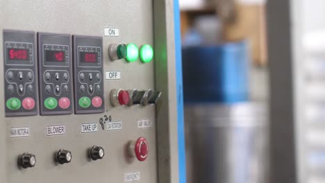 industrial machine control panel at plastics factory with bokeh background