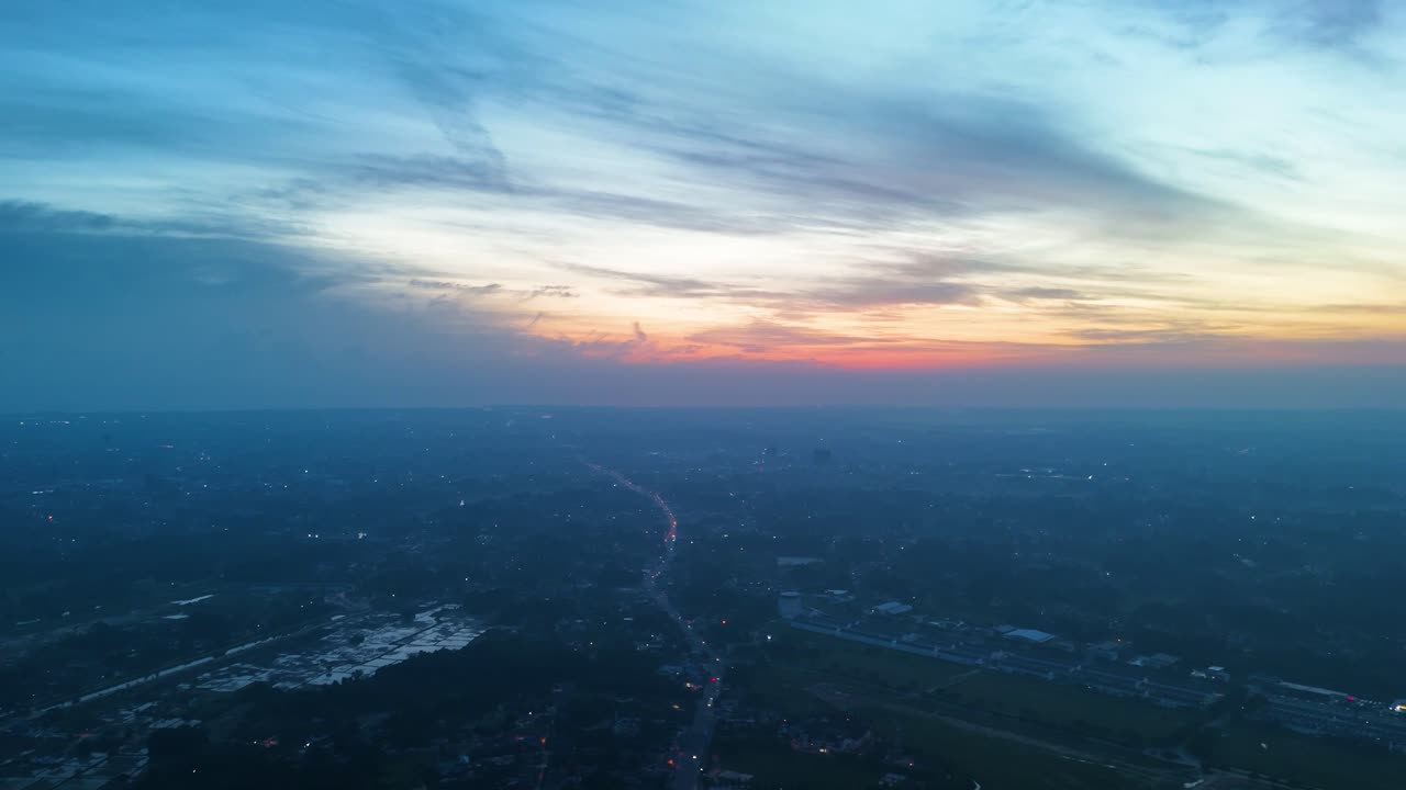Pan drone shot of Kota Bharu cityscape at dawn with blue hour light in the state of Kelantan, Malaysia