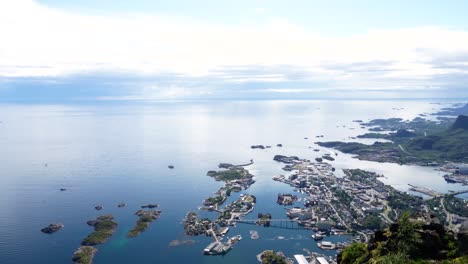 Toma-Aérea-De-Picos-Montañosos-Con-La-Ciudad-De-Lofoten-Detrás-De-Ellos-En-Lofoten,-Noruega