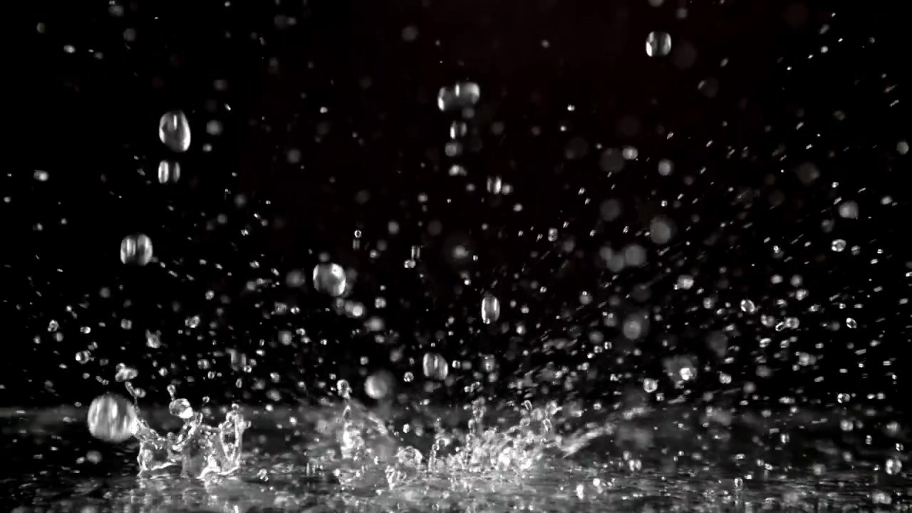 Slow Motion Water Drops Splashing on a Dark Surface