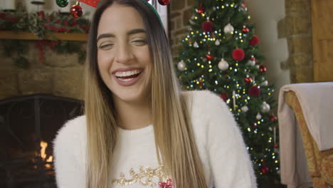 young woman talking and laughing to camera during christmas video call