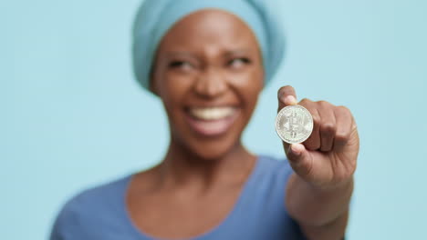 woman holding a bitcoin coin