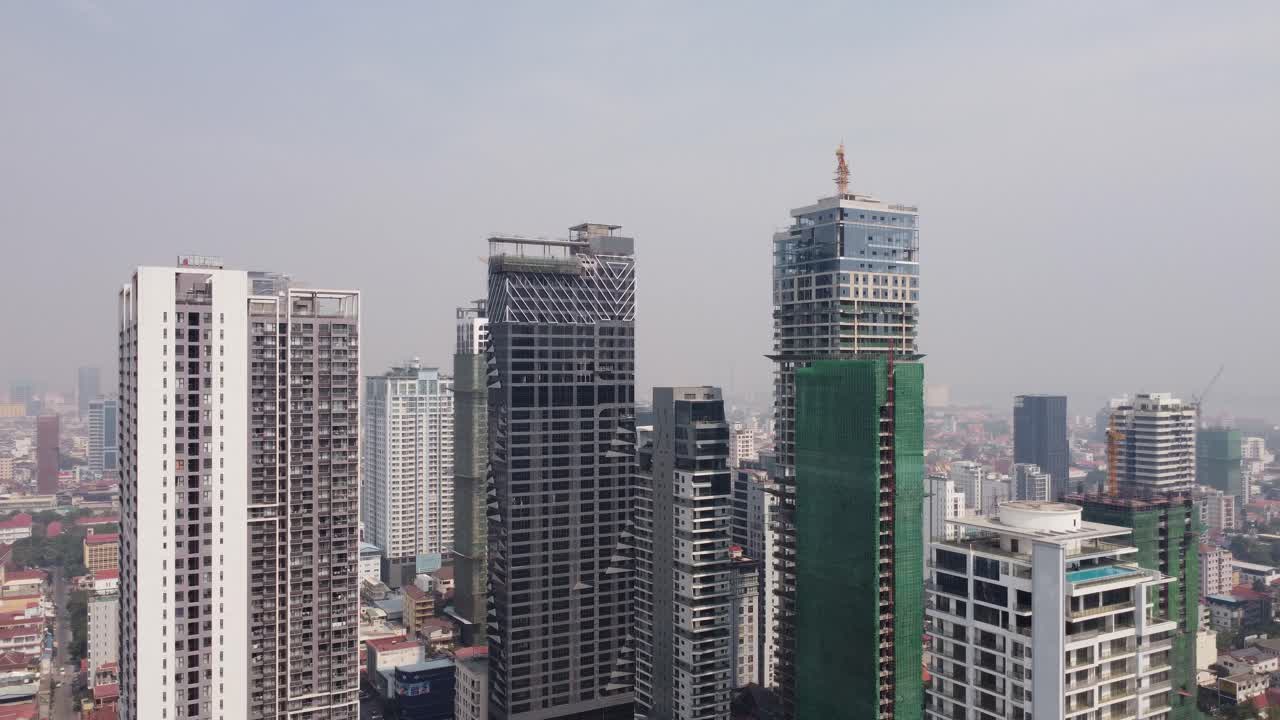Urban skyline buildings construction in Phnom Penh city covered in hazy sky due to air pollution, Drone view