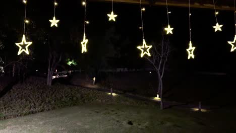 Hanging star lights illuminate a serene garden