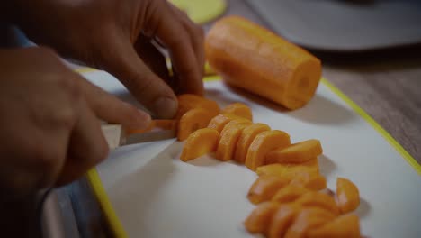 hombre cortando verduras a mano. vista de cerca de un hombre cortando zanahorias a mano en la tabla de cortar. nutrición orgánica. preparar una comida sabrosa. cocina de alimentos y concepto de personas. cocina de comida saludable en casa.