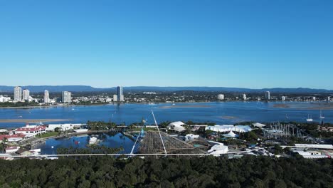 unique view of a wooden rollercoaster being constructed close to a coastal waterway with a mountain backdrop