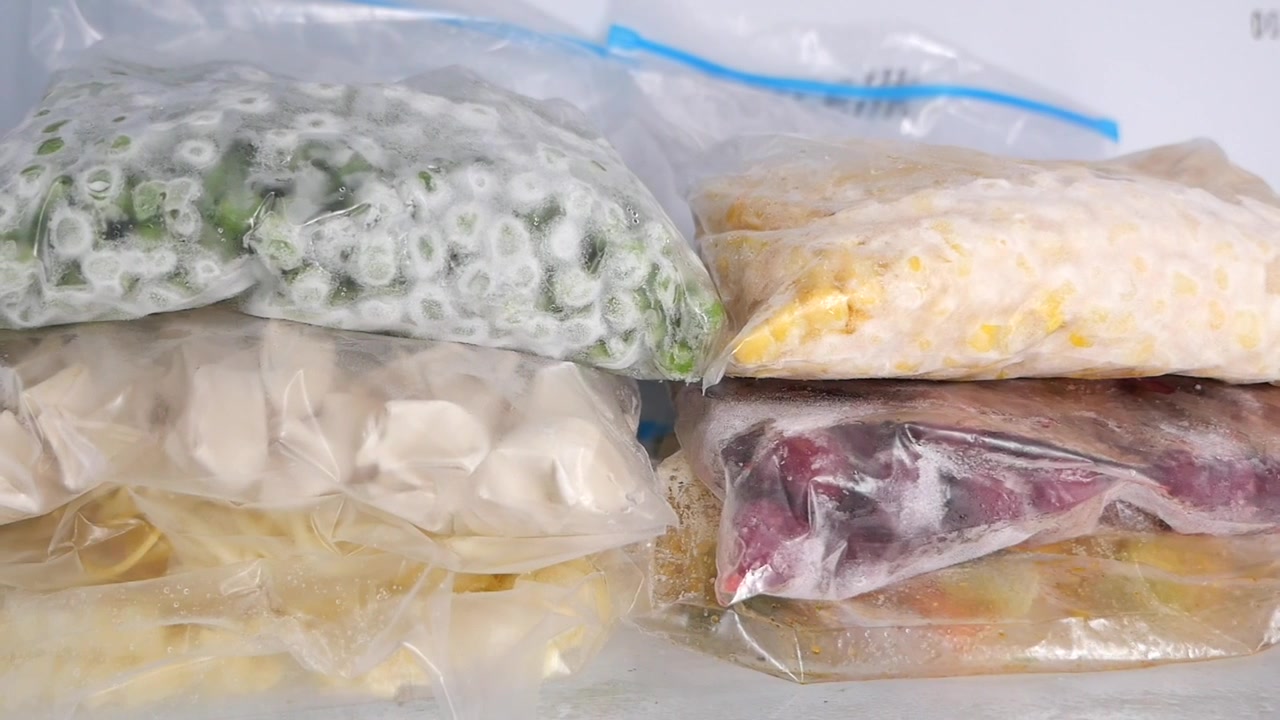 Verschiedenes gefrorenes Gemüse und Lebensmittel in Plastiktüten im Gefrierschrank