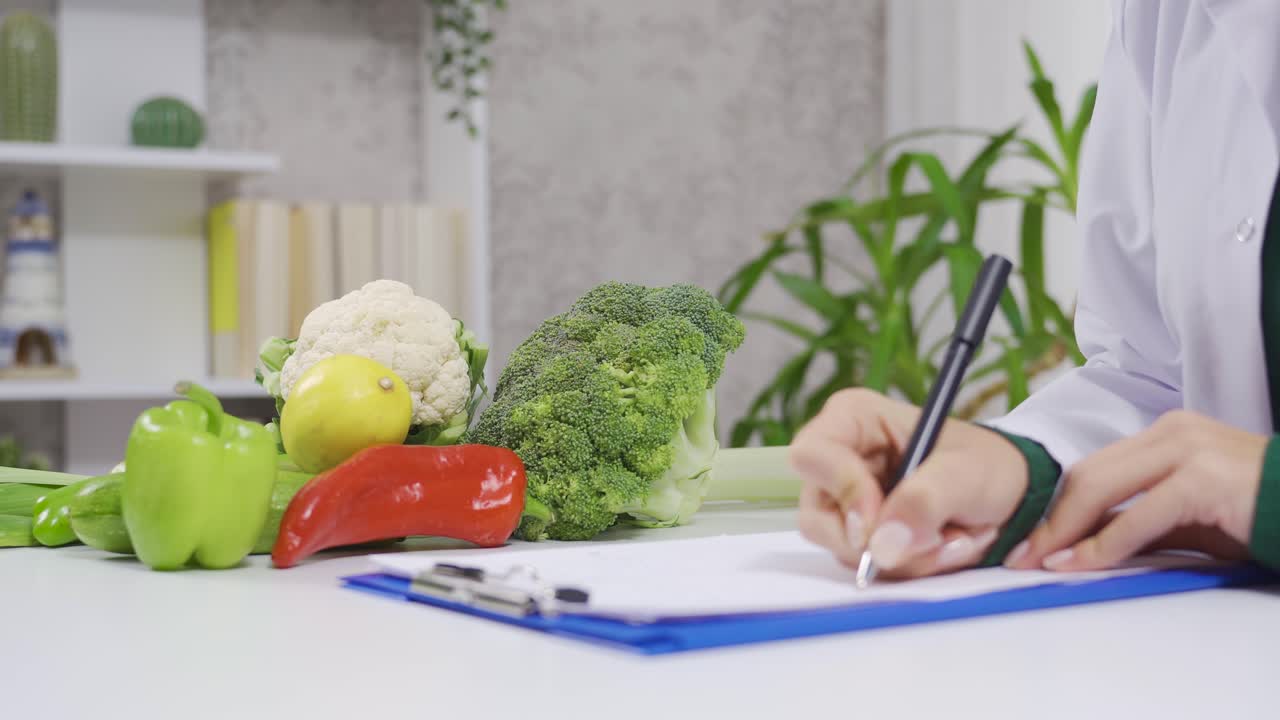 mujer dietista tomando notas y preparando el horario de las comidas.