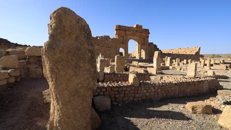 Ancient-Roman-ruins-in-Sbeitla,-Tunisia-under-clear-blue-sky,-stone-arches-and-columns